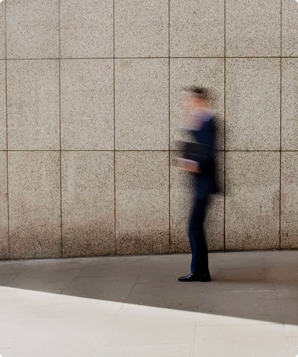 A person in motion in front of a stone facade